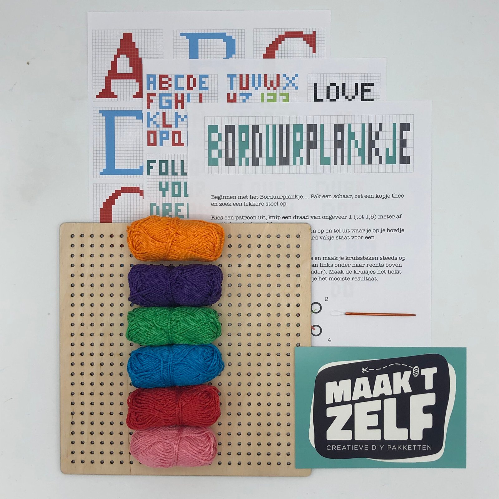 Compleet borduurplankje DIY pakket van MaakTZelf met houten plank, kleurrijk garen, naald en borduurpatronen – creatief handwerkproject voor thuis.