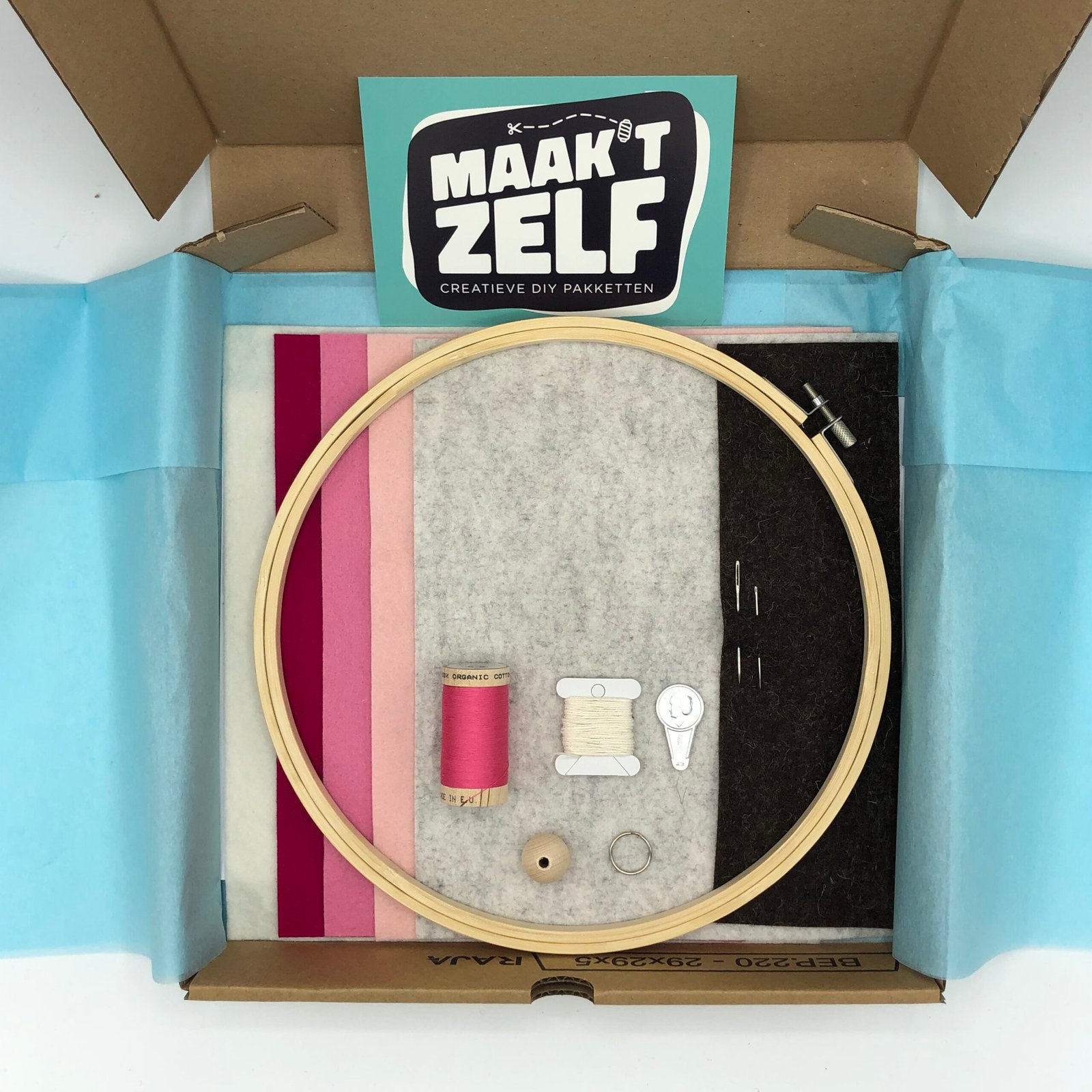 DIY viltpakket in cadeauverpakking met roze, grijs en wit vilt, houten borduurring, garen en accessoires van MaakTzelf.