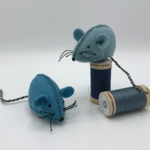 Twee blauwe wolvilt muisjes, waarbij er 1 op een blauw klosje garen zit, met een witte achtergrond