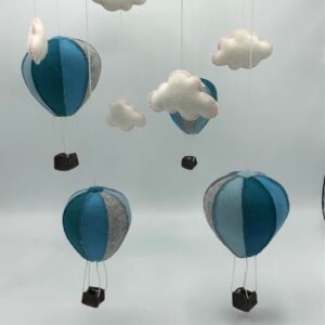 DIY viltpakket met blauwe en grijze luchtballonnen en witte wolkjes, hangend als mobiel van MaakTzelf.